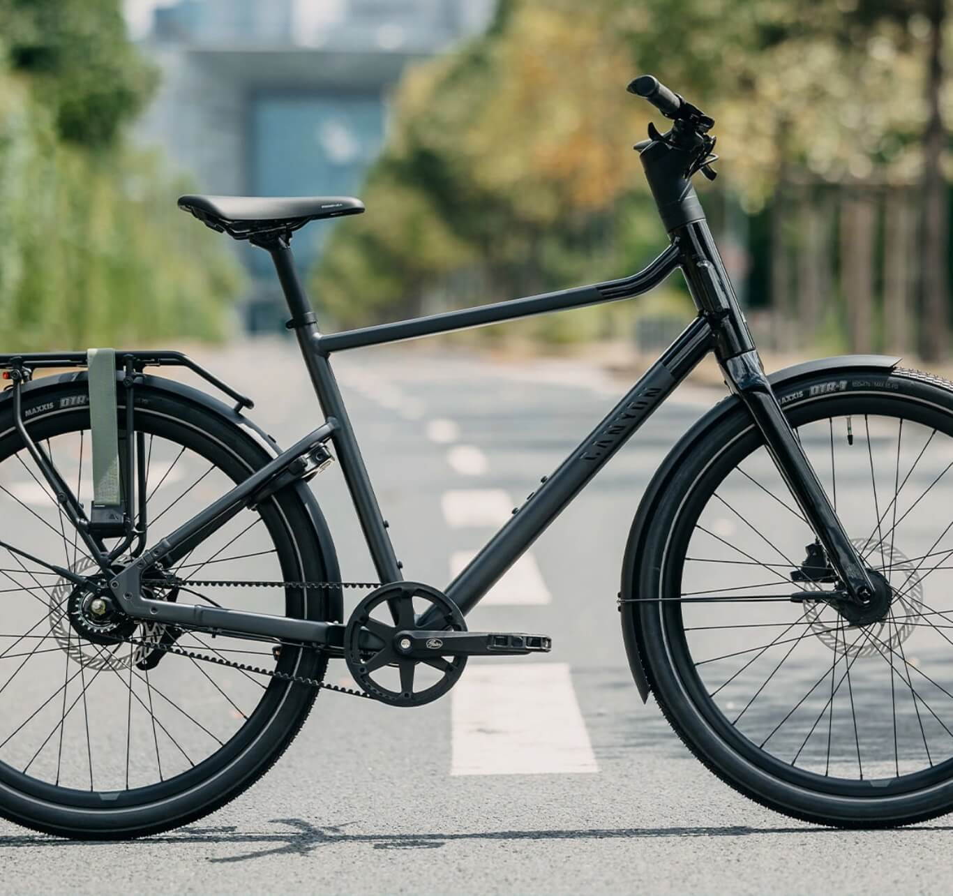 Grau­es Citybike mit tiefem Einstieg steht auf einer leeren Straße.