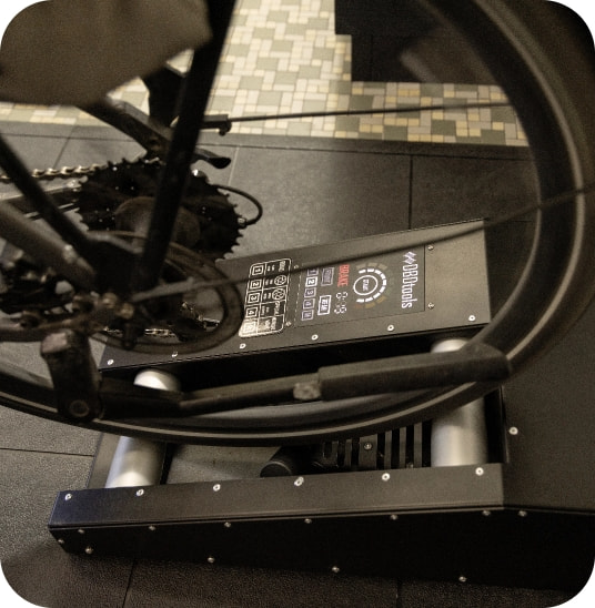 Fahrrad läuft auf einem Rollenprüfstand in der Werkstatt.